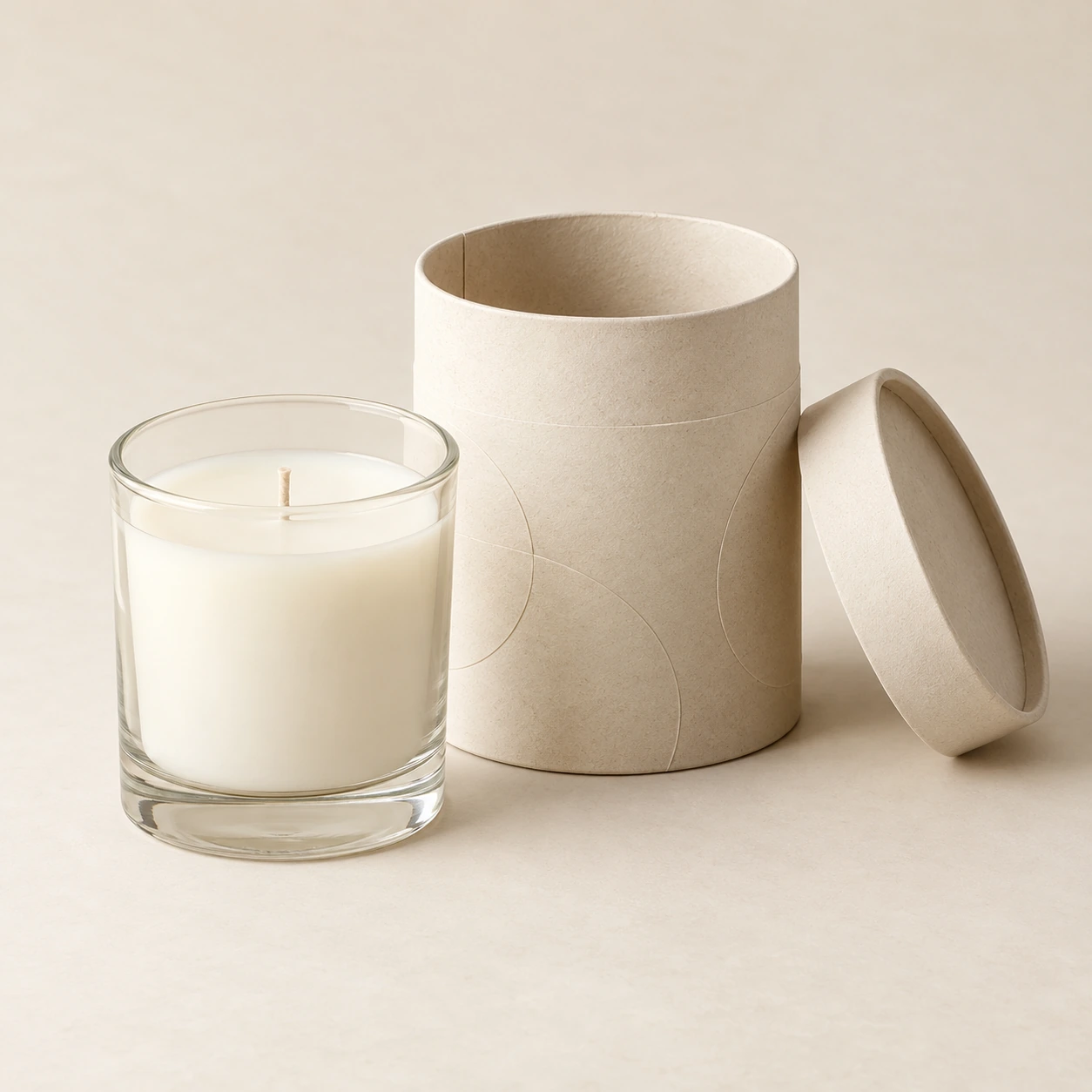 AI concept: an ivory cylindrical paper tube with a round removable lid beside a clear glass candle jar.
