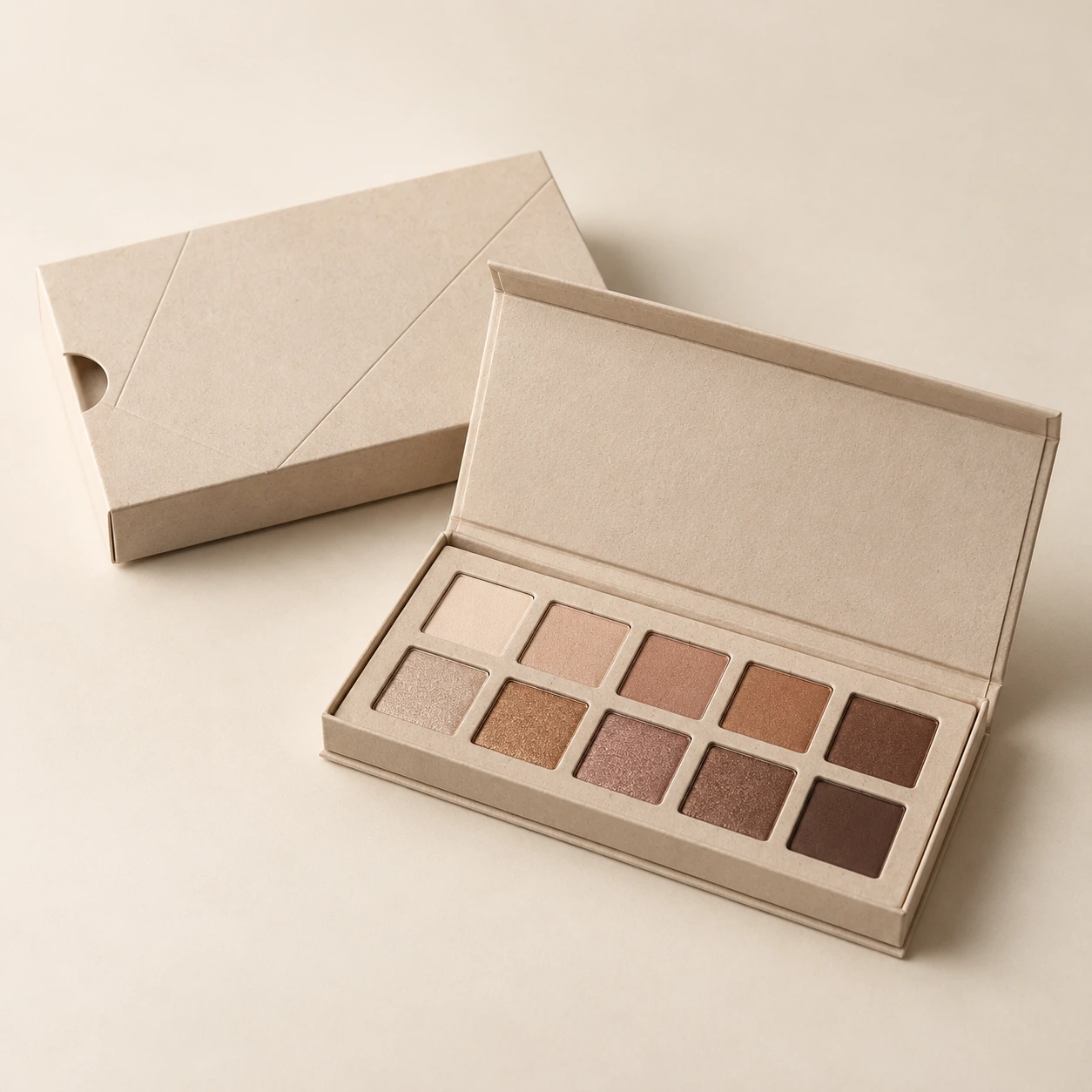 AI concept: an open neutral-toned eyeshadow palette beside its matching ivory patterned outer packaging.