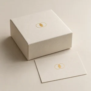 AI concept: an ivory box and paper sample with a small gold-coloured reflective foil motif.