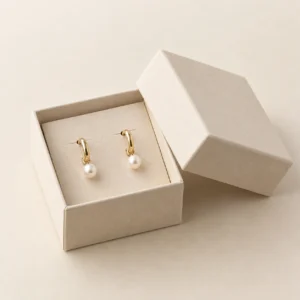 AI concept: ivory earring box with a pair of dangling earrings, catalog view.