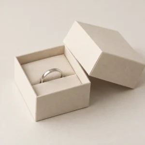 AI concept: small ivory ring box with a raised ring support, catalog view.